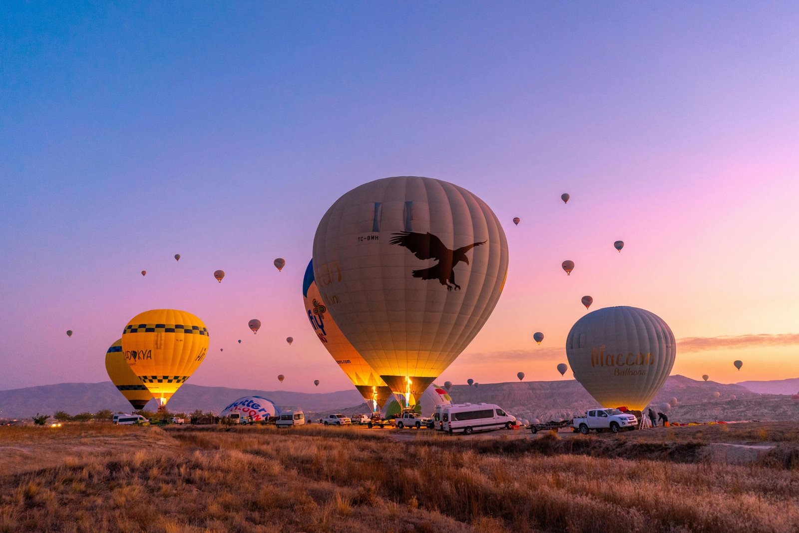 Vibrant hot air balloons fill the sky at sunrise in Cappadocia, Turkey.